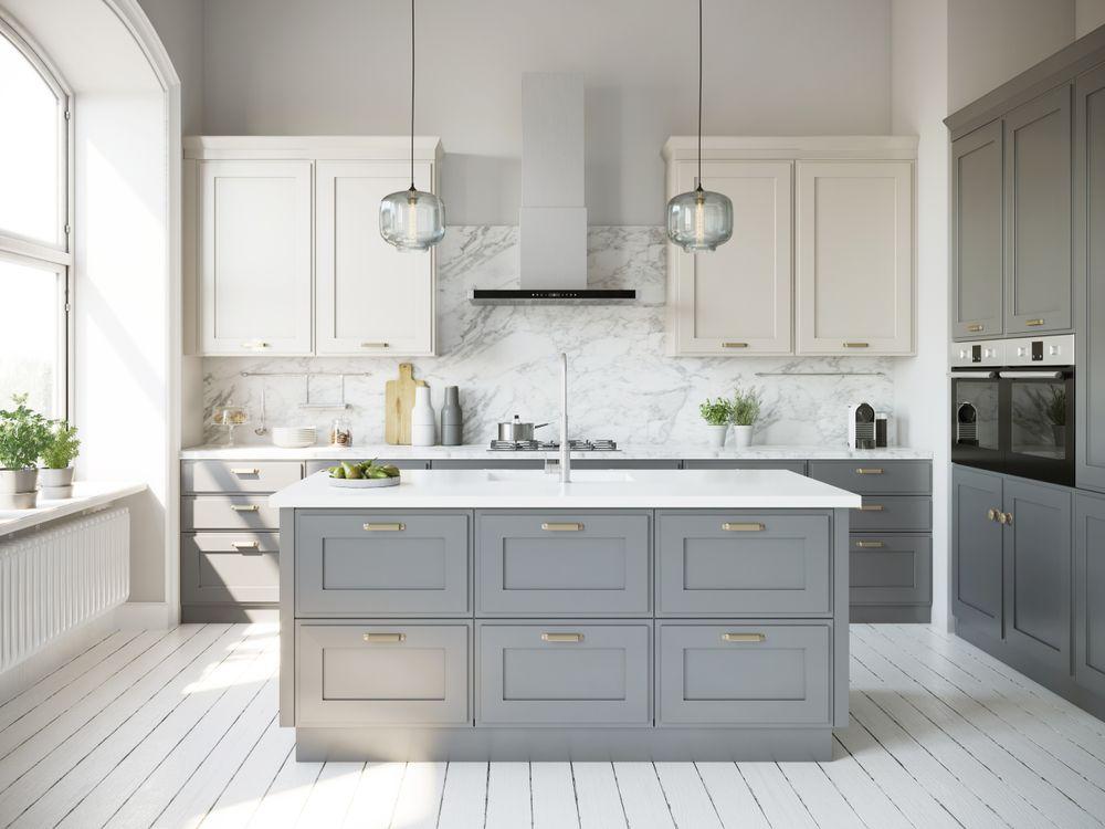 Bright custom kitchen with marble island and shaker cabinetry